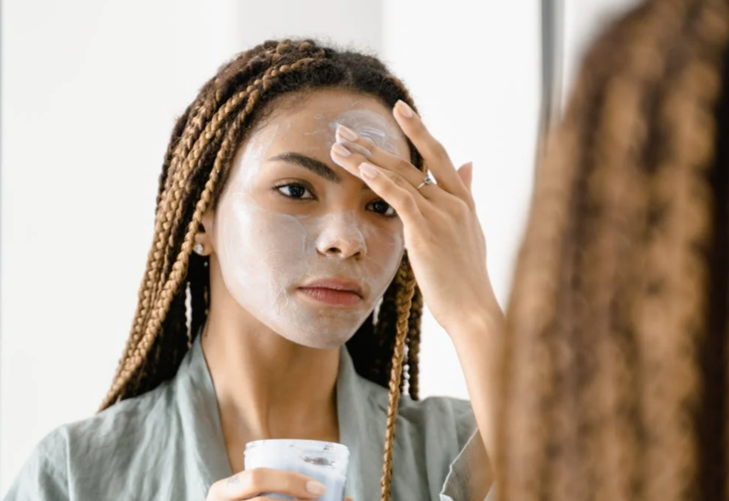 Beautiful African American woman applying face cream